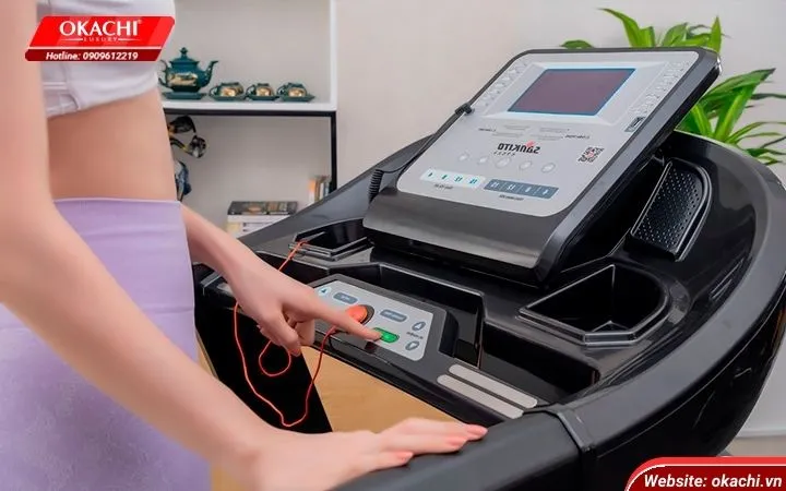 một cô gái đứng cạnh máy chạy bộ